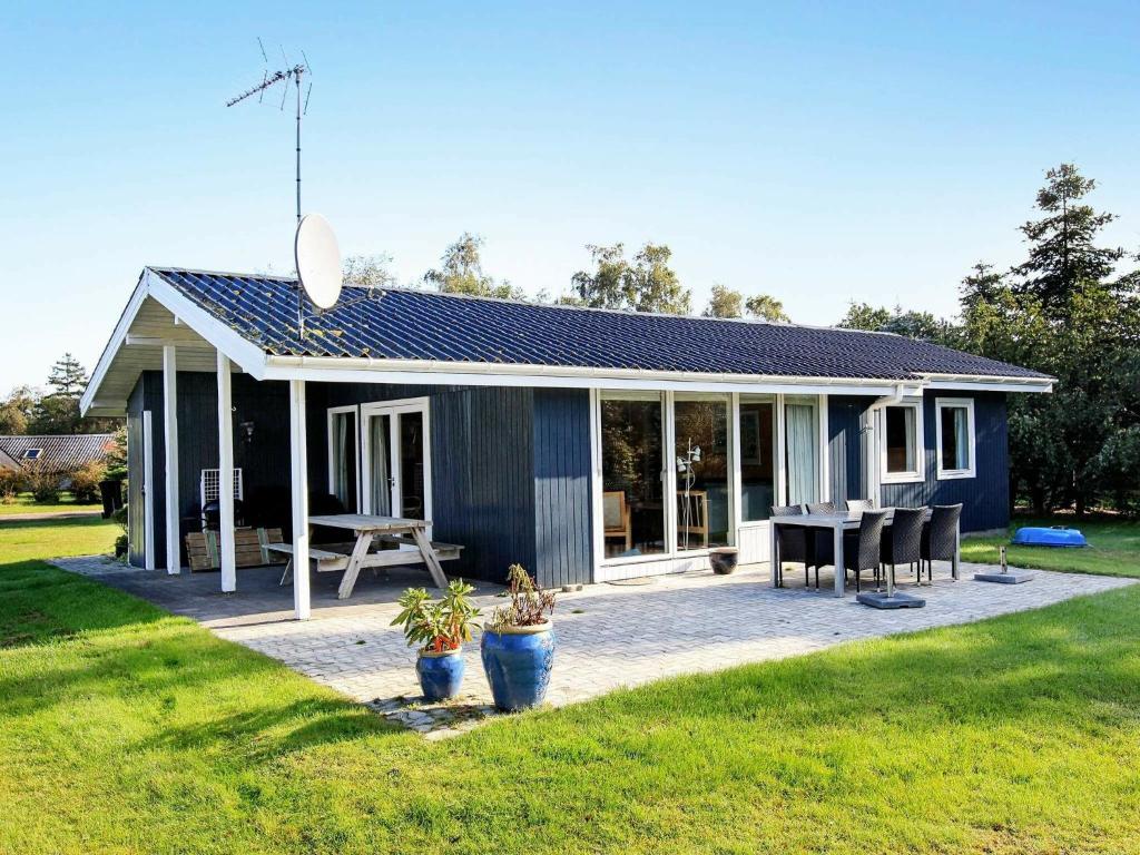 une petite maison bleue avec une table et des chaises dans l'établissement Holiday Home Filosofstræde, à Dannemare