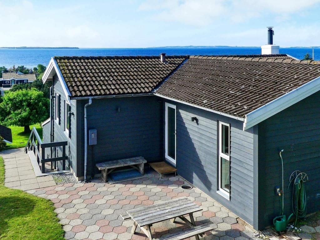 a blue house with a picnic table and a bench at 8 person holiday home in Ebeltoft in Ebeltoft
