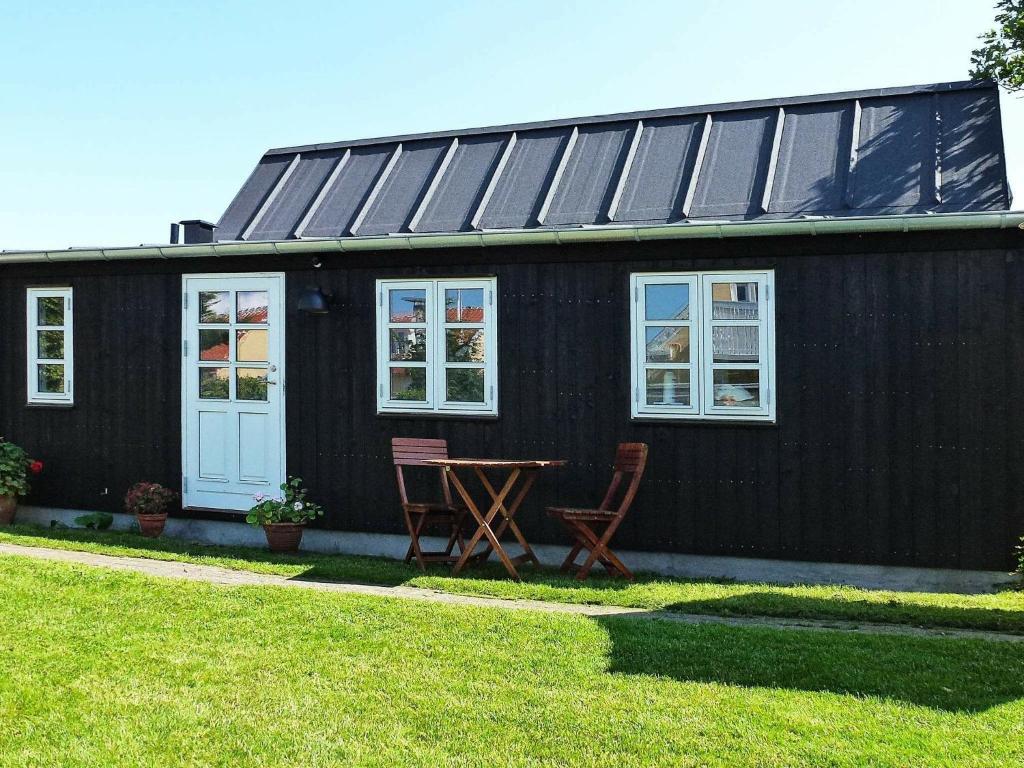 a black house with two chairs and a table in front of it at 4 person holiday home in Skagen-By Traum in Skagen
