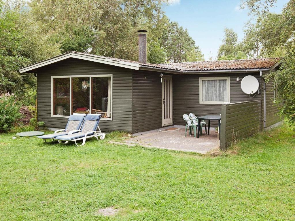 エーベルトフトにある6 person holiday home in Ebeltoftの小さな家で、パティオ、テーブル、椅子が備わります。