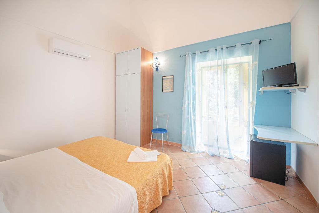 a bedroom with a bed and a tv and a window at Solcalante in Procida