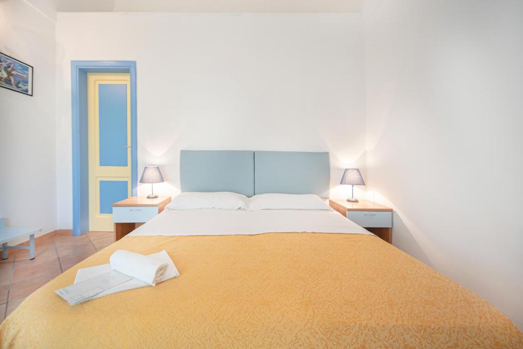 a bedroom with a large bed with two lamps at Solcalante in Procida