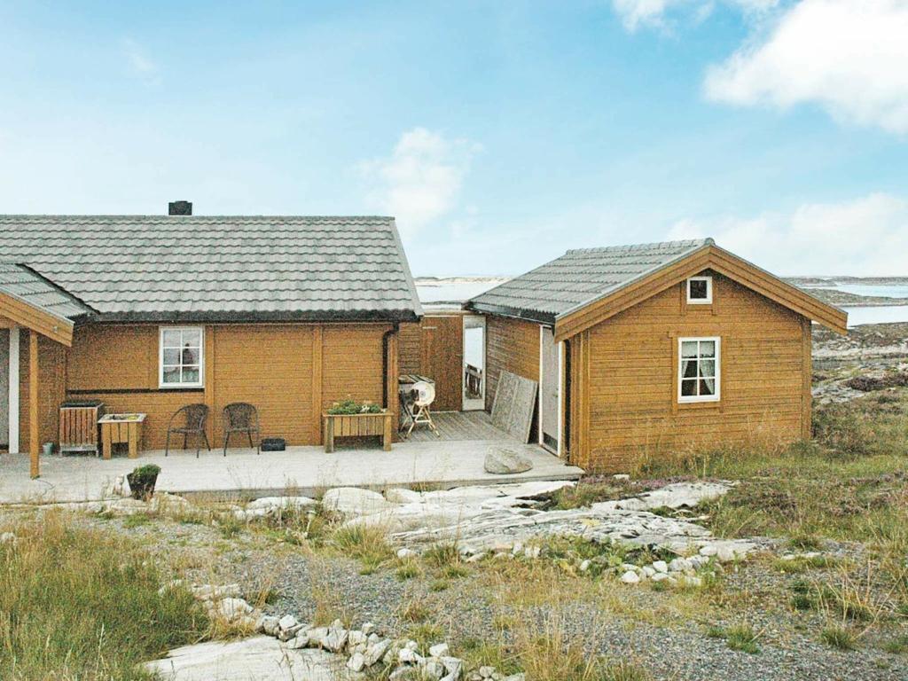 a house with a dog standing in front of it at Three-Bedroom Holiday home in Dyrvik in Tuvnes