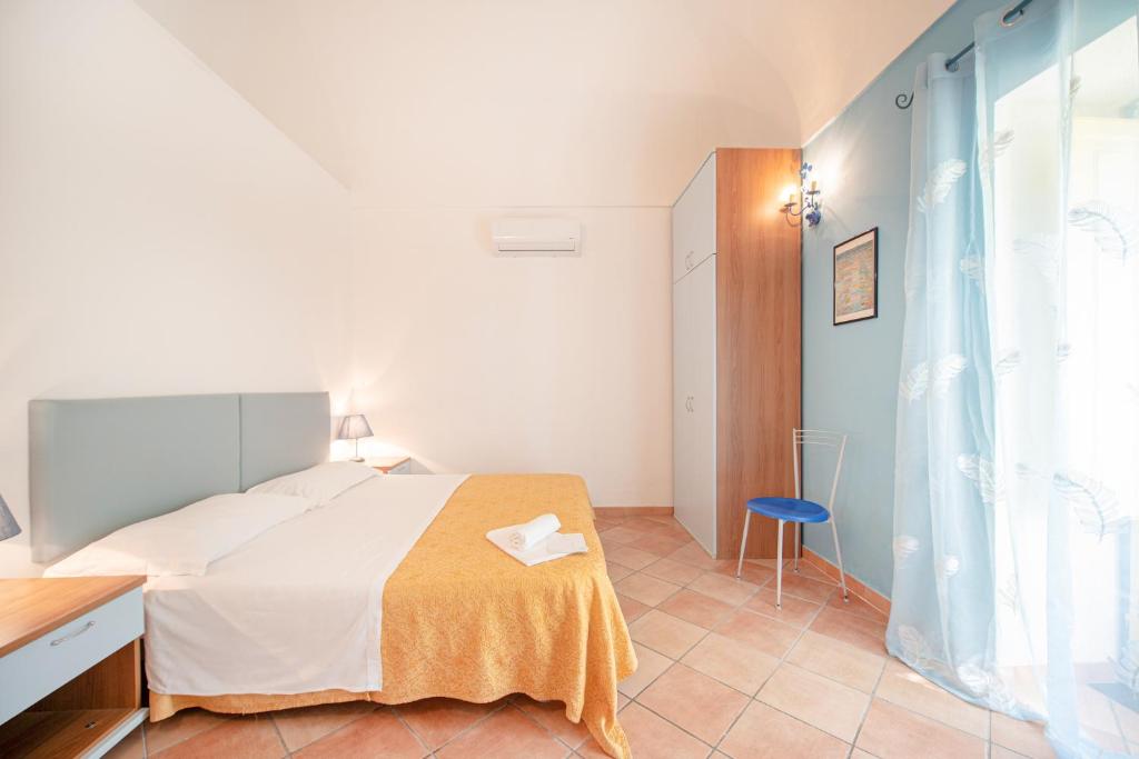 a bedroom with a bed and a blue chair at Solcalante in Procida