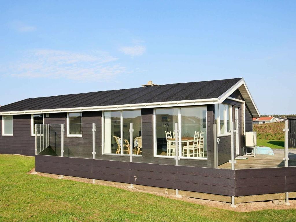 Nørre Lyngbyにある6 person holiday home in L kkenのデッキ付きのコンサバトリーのある家