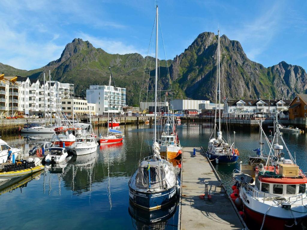 a group of boats docked in a harbor with mountains at 6 person holiday home in Svolv r in Svolvær