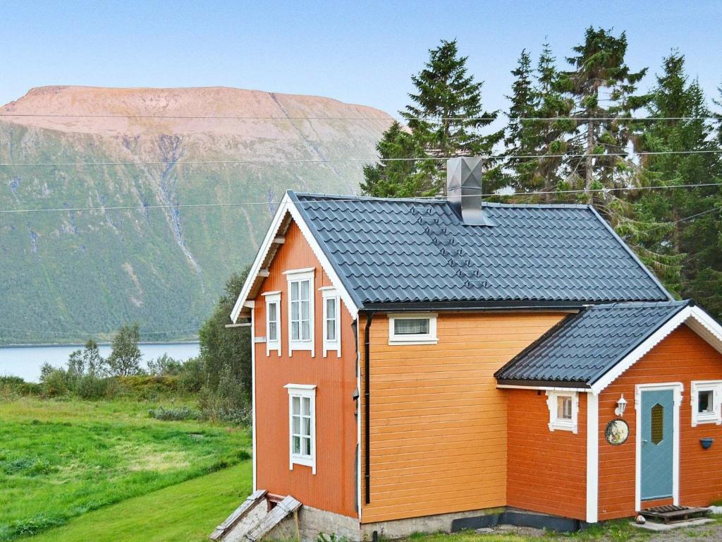 a tiny house with a mountain in the background at Three-Bedroom Holiday home in Gullesfjord in Flesnes