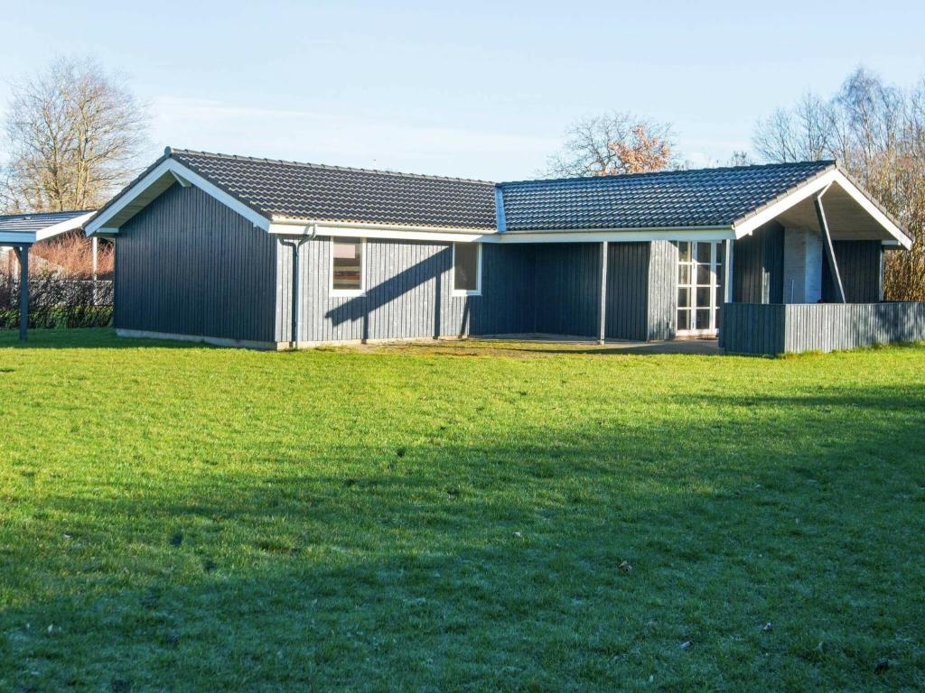 a house with a green field in front of it at 8 person holiday home in B rkop in Egeskov