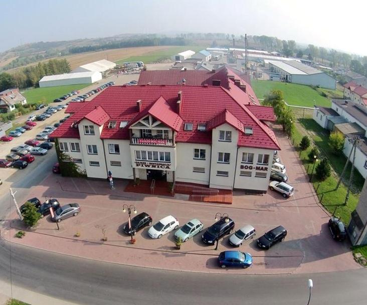 una casa grande con coches aparcados en un aparcamiento en Zajazd Bog-Mar en Rymanów