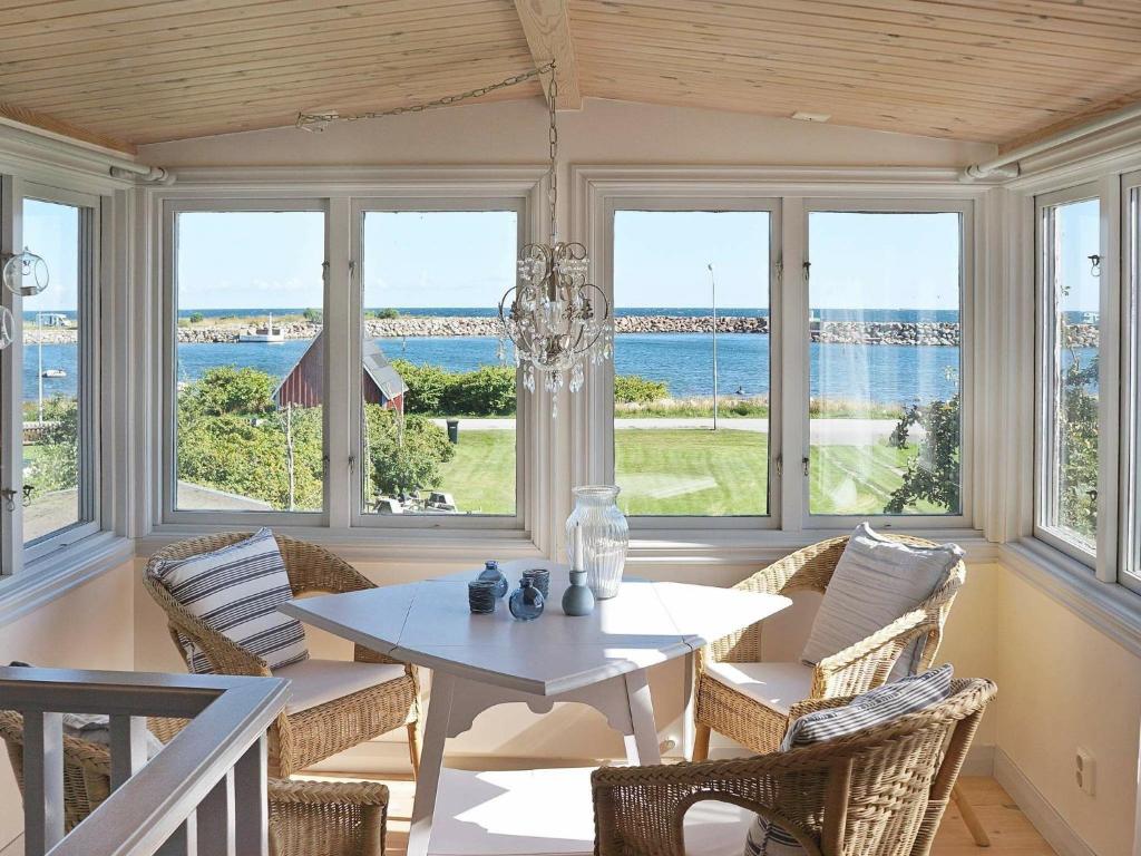 Hällevikにある5 person holiday home in S LVESBORGのダイニングルーム(テーブル、椅子、窓付)