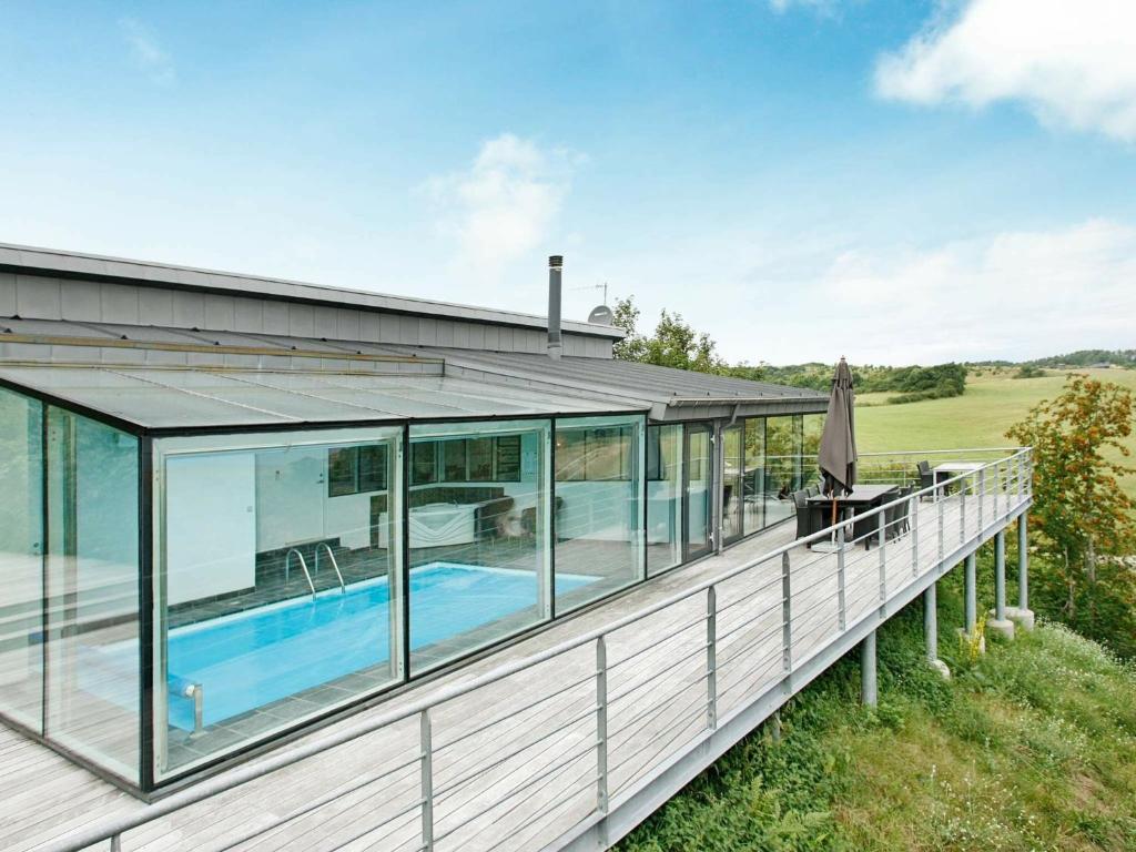 an exterior view of a house with a pool and windows at Three-Bedroom Holiday home in Knebel 23 in Knebel