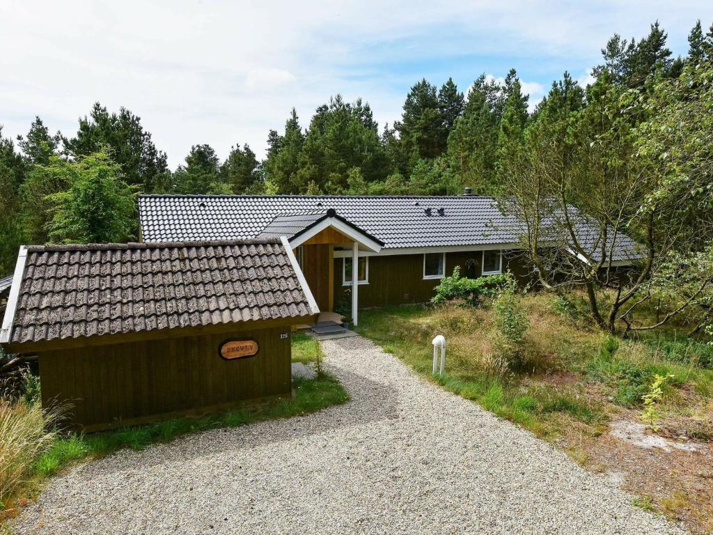 una casa con una entrada de grava delante de ella en 8 person holiday home in N rre Nebel en Lønne Hede