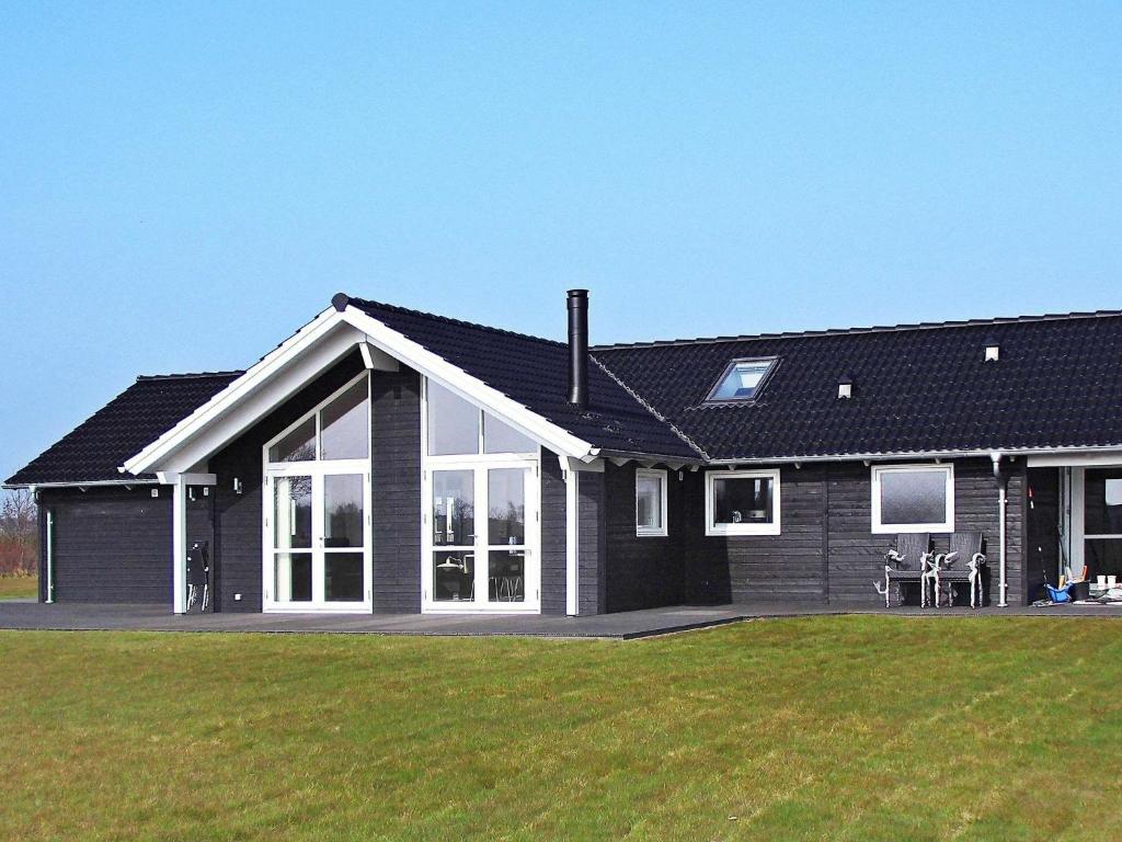 uma casa com um telhado preto e um jardim verde em 10 person holiday home in Sydals em Vibøge