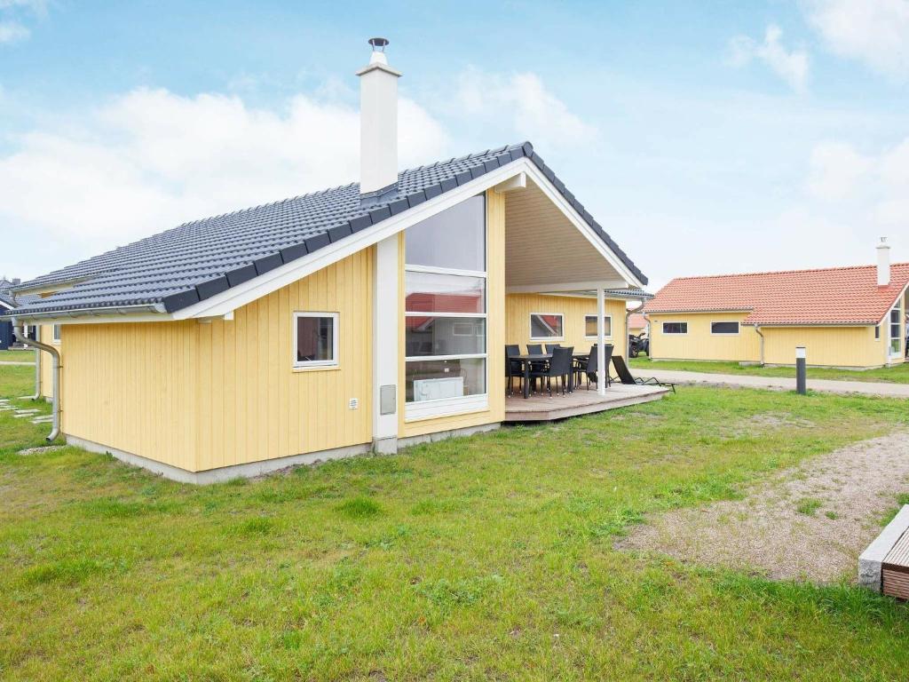 a yellow house with a large yard at 10 person holiday home in Gro enbrode in Großenbrode