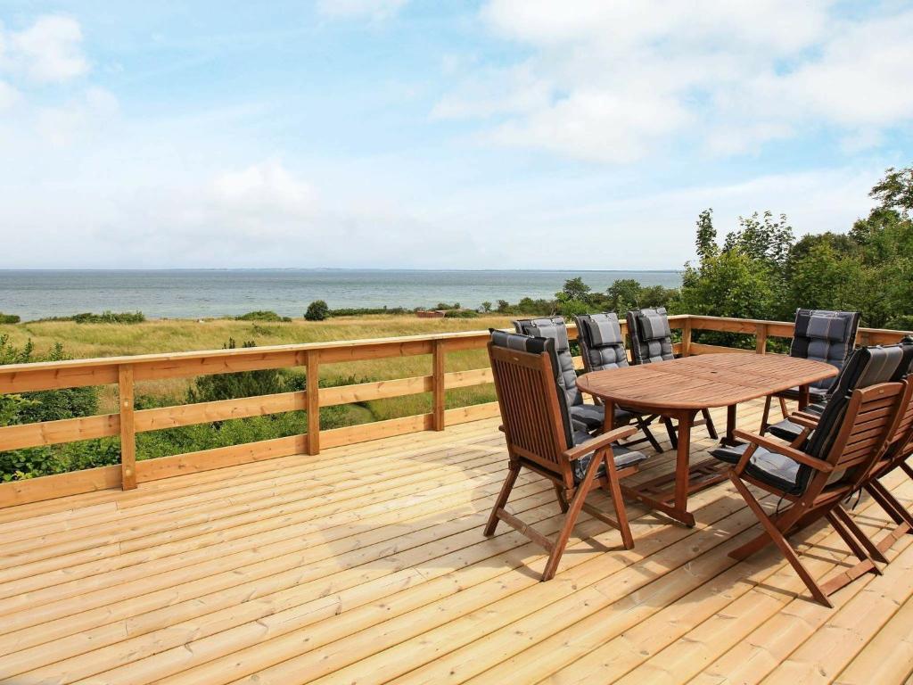 a wooden deck with a wooden table and chairs at 8 person holiday home in Asn s in Asnæs
