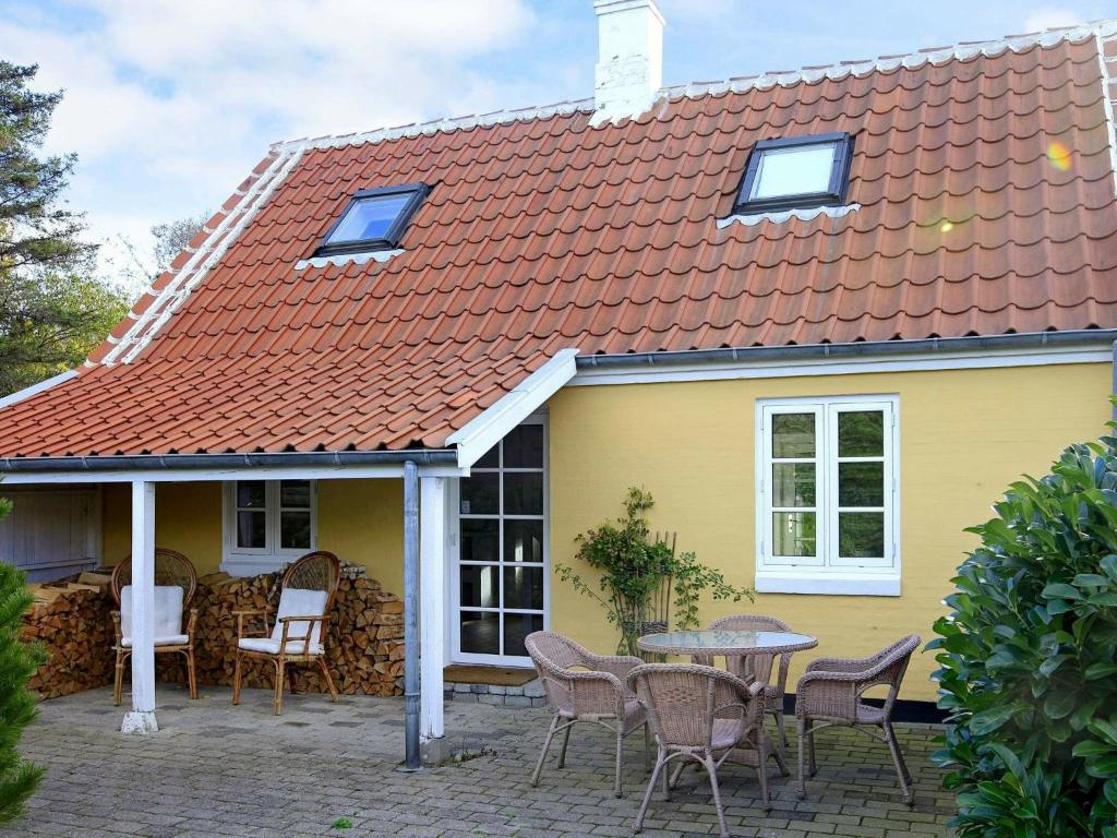 斯卡恩的住宿－4 person holiday home in Skagen，黄色的房子,配有桌子和椅子