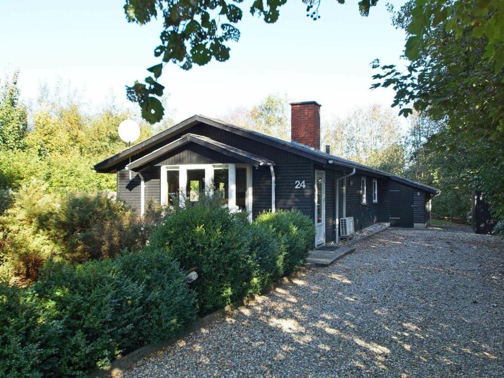 a small black house with a brick chimney on it at 6 person holiday home in Hemmet in Hemmet