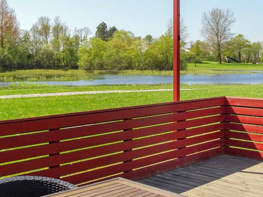 una panchina rossa con vista sul lago di Holiday home Tranekær IV a Tranekær