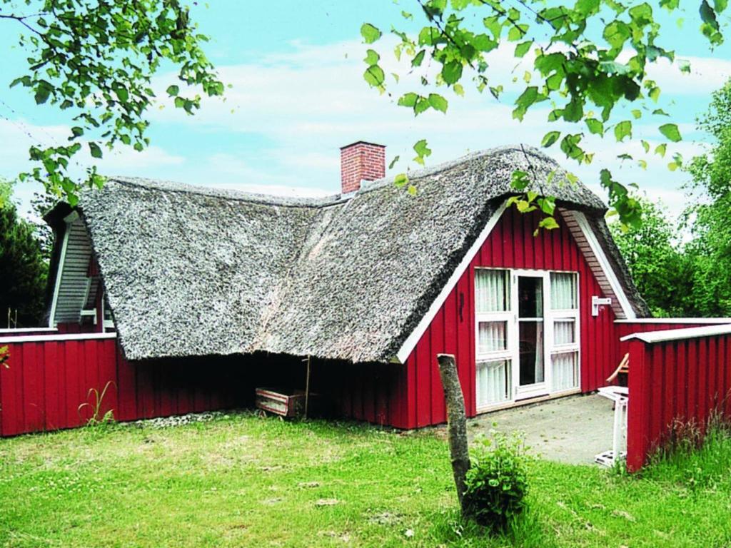 una casa roja con techo gris en Three-Bedroom Holiday home in Nørre Nebel 16, en Lønne Hede