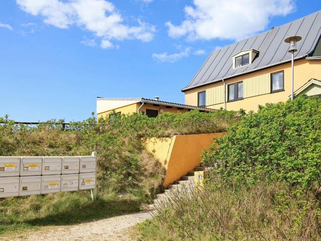 伊厄斯灘的住宿－4 person holiday home in Vejers Strand，一座房子,位于一座建筑物旁的山顶上