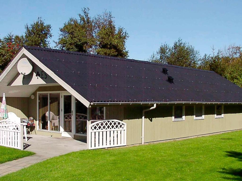 Falen的住宿－6 person holiday home in Hemmet，一个带黑色屋顶和草地庭院的车库