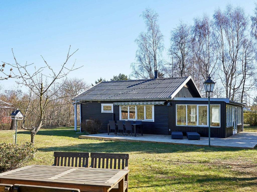 a small house with a picnic table in front of it at Holiday home Hasle III in Hasle