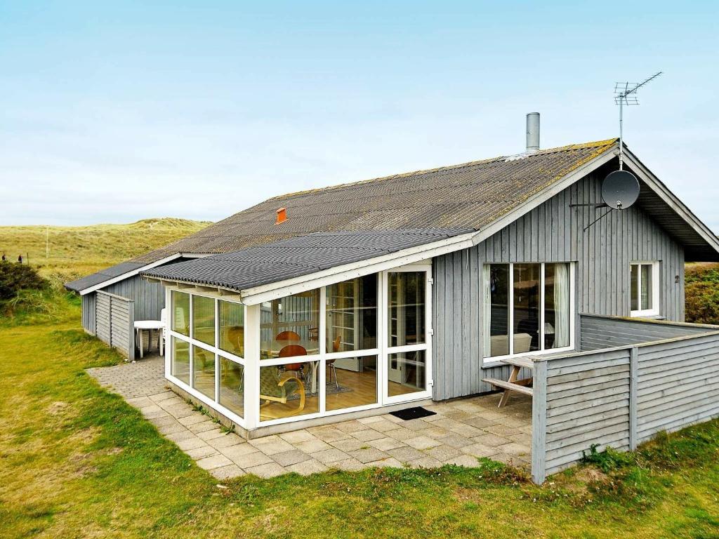 a gray house with large windows on a patio at 8 person holiday home in Harbo re in Harboør