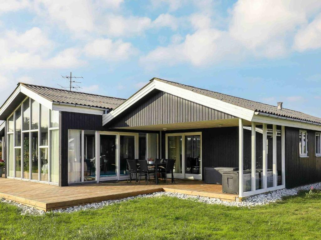 una casa con porche y terraza en 12 person holiday home in Ringk bing, en Klegod