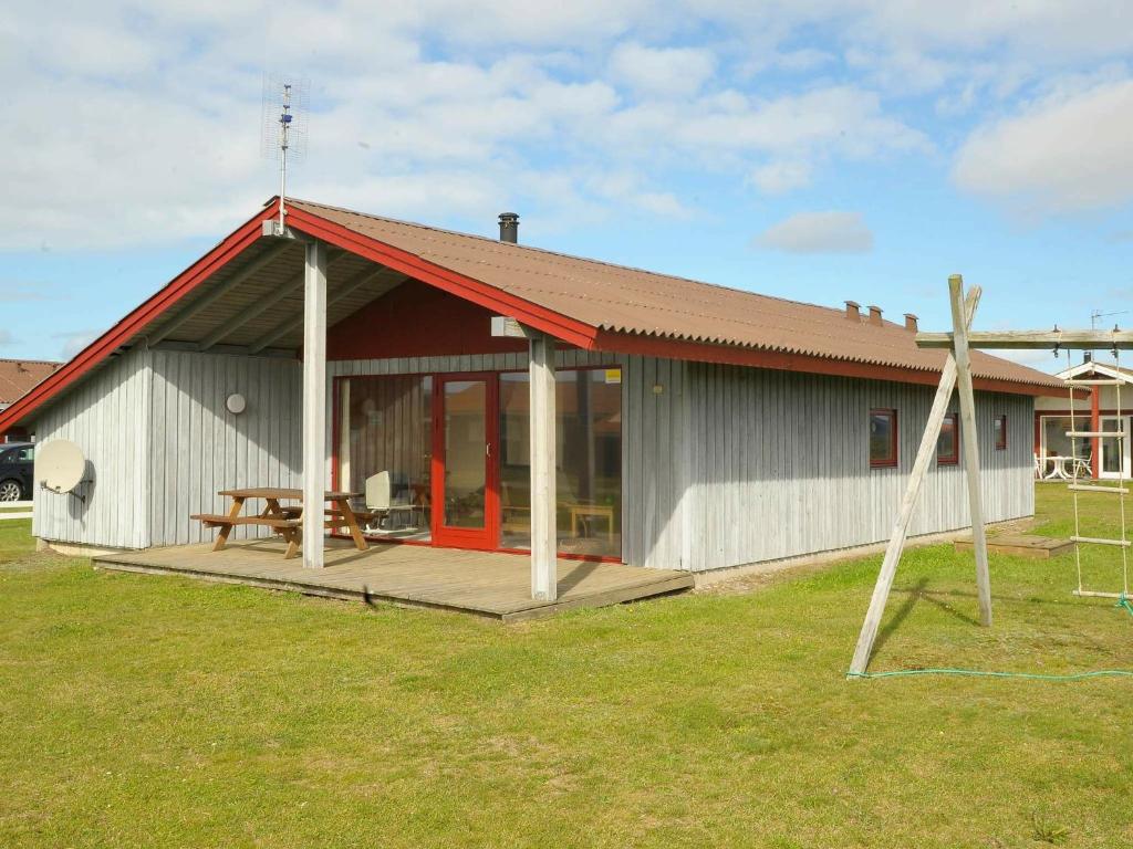 una casa con porche y mesa de picnic en 8 person holiday home in Harbo re, en Harboør
