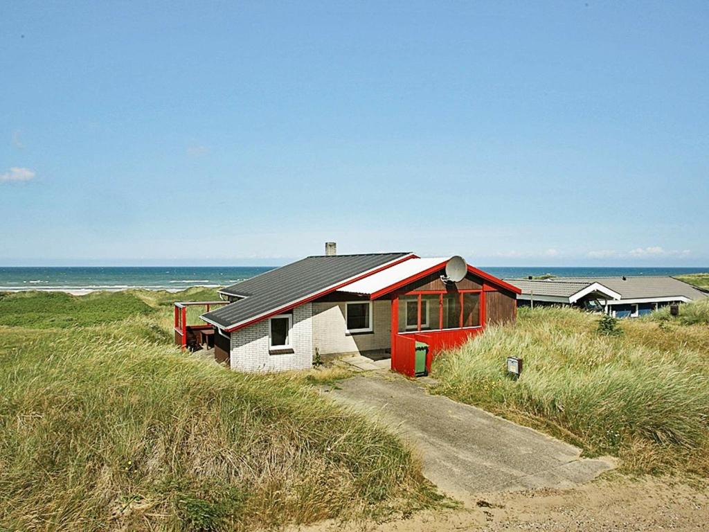 GrønhøjにあるThree-Bedroom Holiday home in Løkken 65の浜辺の赤白家屋