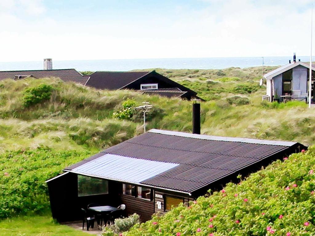 Two-Bedroom Holiday home in Løkken 25 في Grønhøj: منزل به لوحات شمسية على جانبه