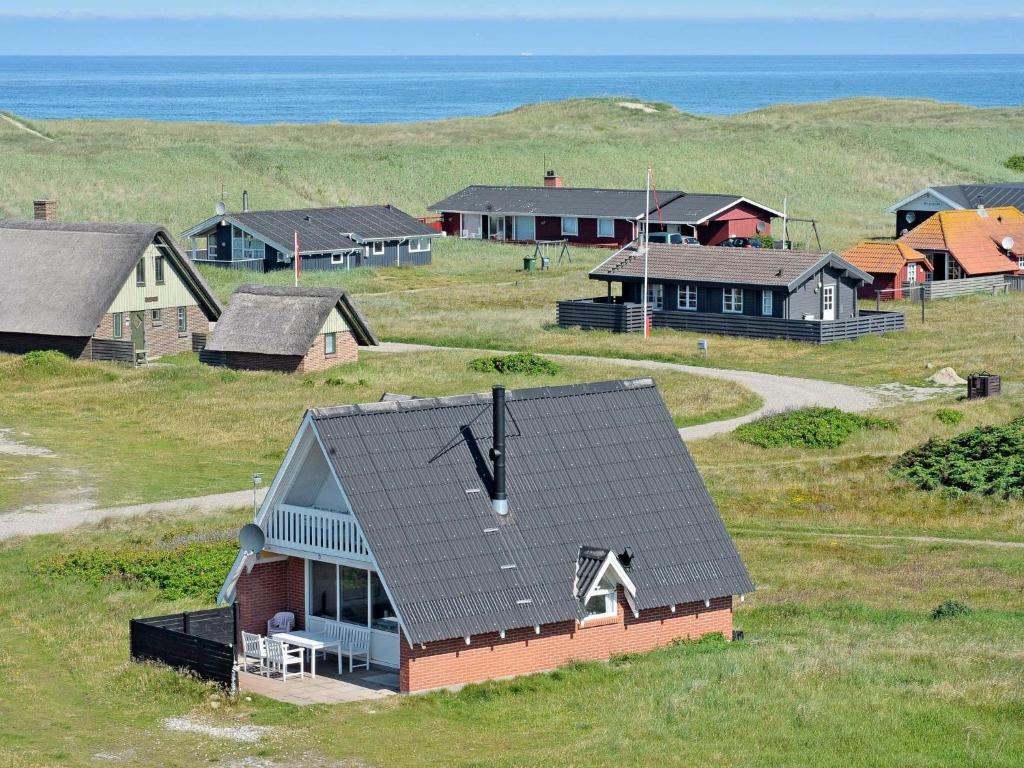 a group of houses with the ocean in the background at Three-Bedroom Holiday home in Harboøre 24 in Harboør