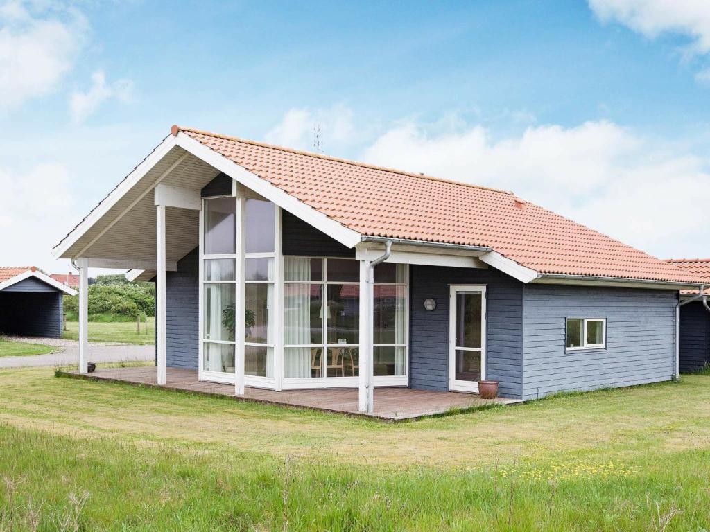 Fjand Gårdeにある8 person holiday home in Ulfborgの赤屋根の小さな青い家