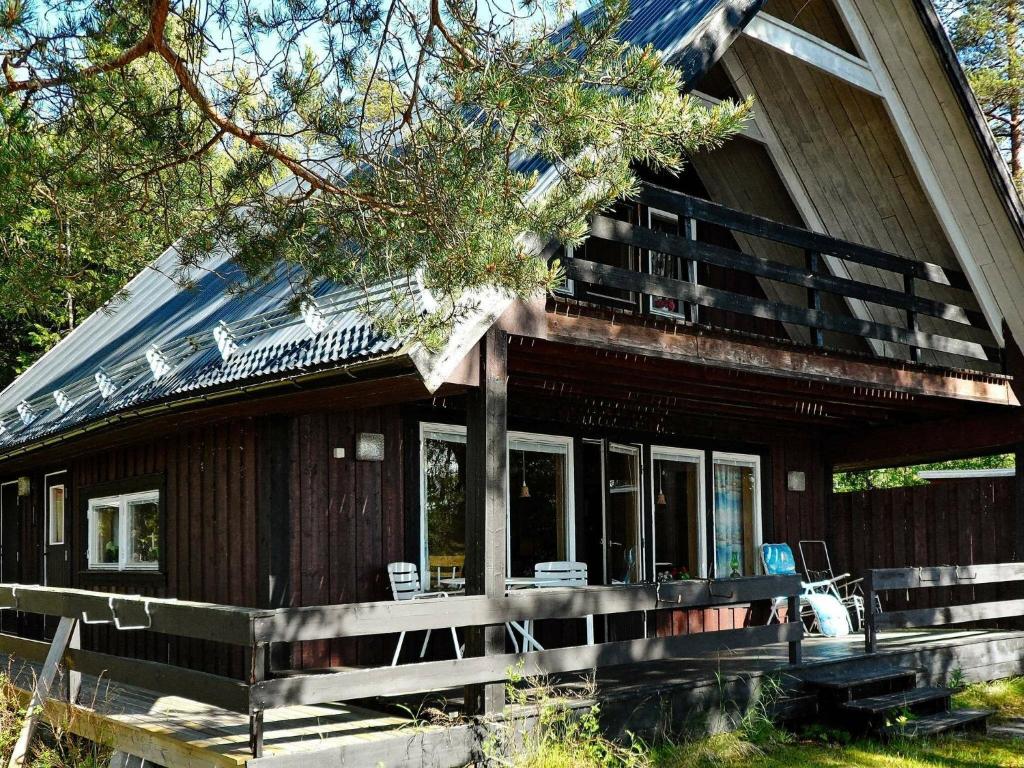 a large wooden house with a porch and windows at 5 person holiday home in L GDE in Himmersundet