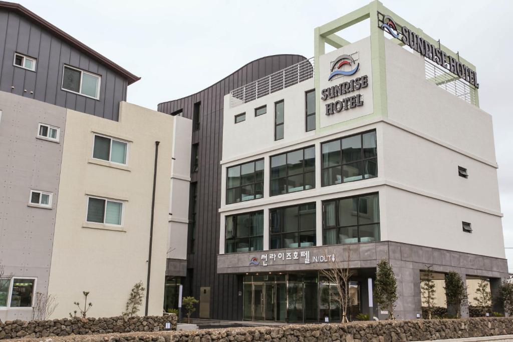 a building with a sign on the front of it at Sunrise Hotel Supjikoji in Seogwipo