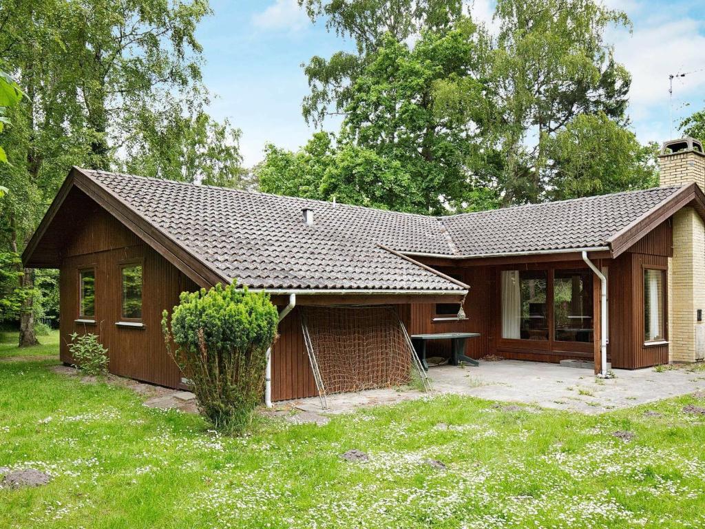 une petite maison dans une cour avec une pelouse dans l'établissement Four-Bedroom Holiday home in Rørvig 2, à Rørvig