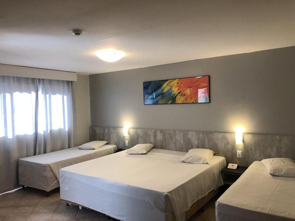 une chambre avec deux lits et un tableau au mur dans l'établissement Brasil Express, à Balneário Camboriú