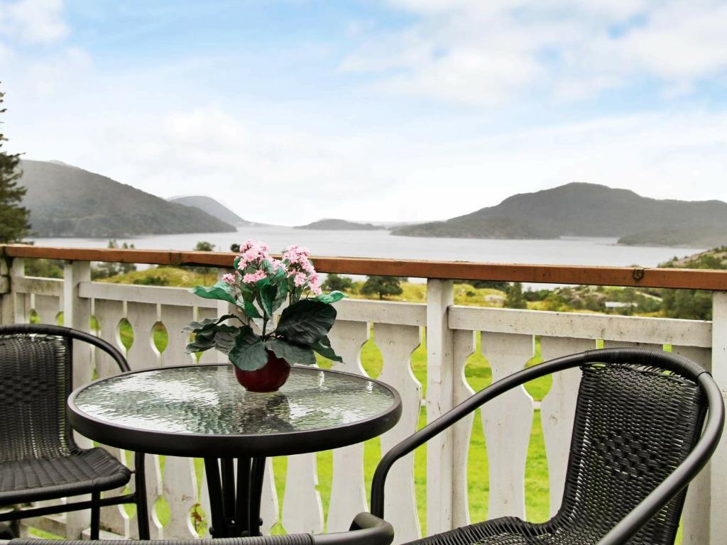 a table with a vase of flowers on a balcony at Five-Bedroom Holiday home in Masfjordnes in Masfjorden