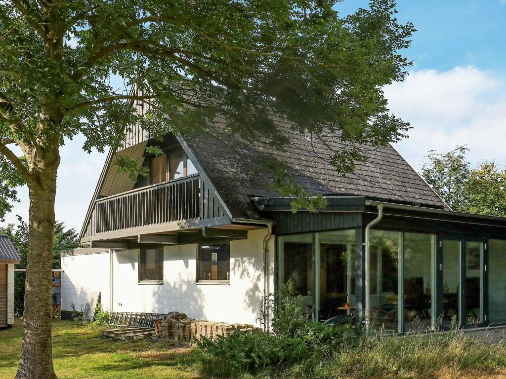 una casa blanca con techo de gambrel en 6 person holiday home in Struer en Struer