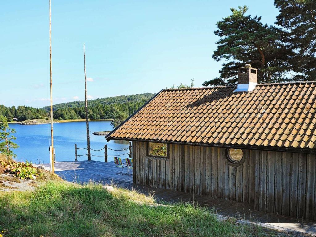 6 person holiday home in HEN N في Sundsandvik: كابينة خشبية مطلة على البحيرة