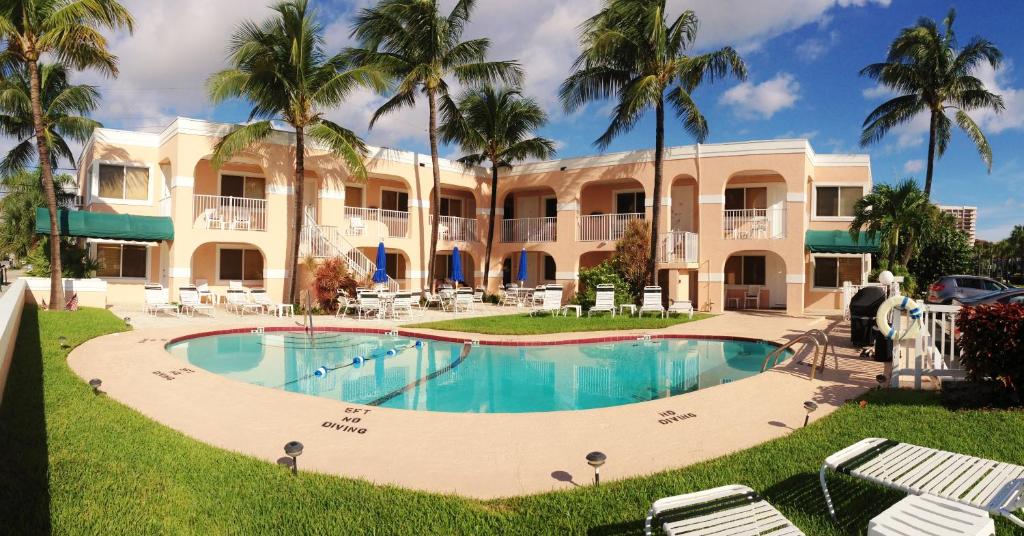 un complejo con piscina frente a un edificio en Coral Key Inn en Fort Lauderdale