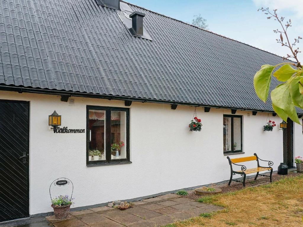 a white house with a bench in front of it at 6 person holiday home in Laholm in Laholm