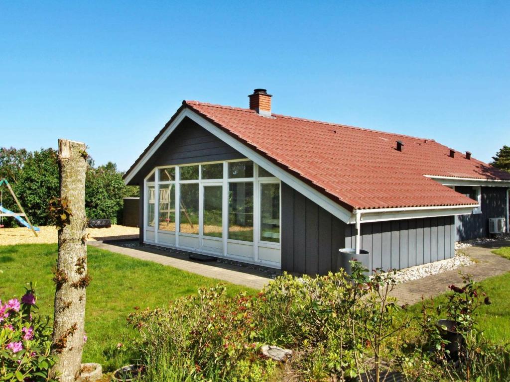 uma pequena casa com um telhado vermelho em 6 person holiday home in Hemmet em Hemmet