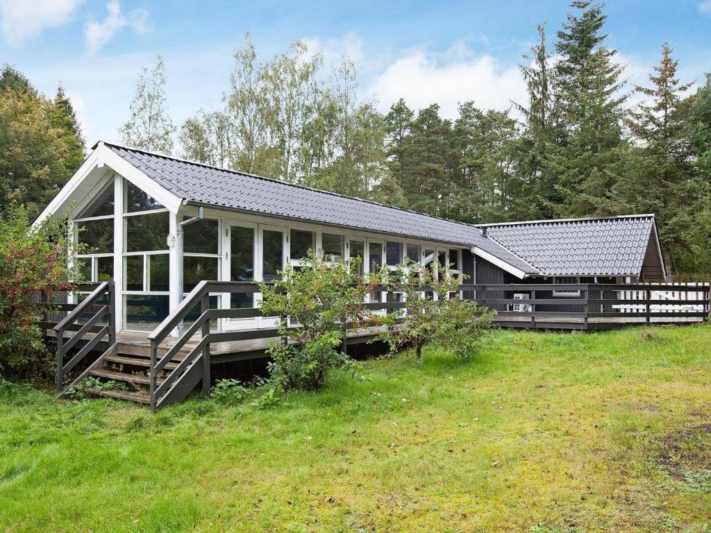 a large house with a porch and a yard at 6 person holiday home in Ebeltoft in Øksenmølle