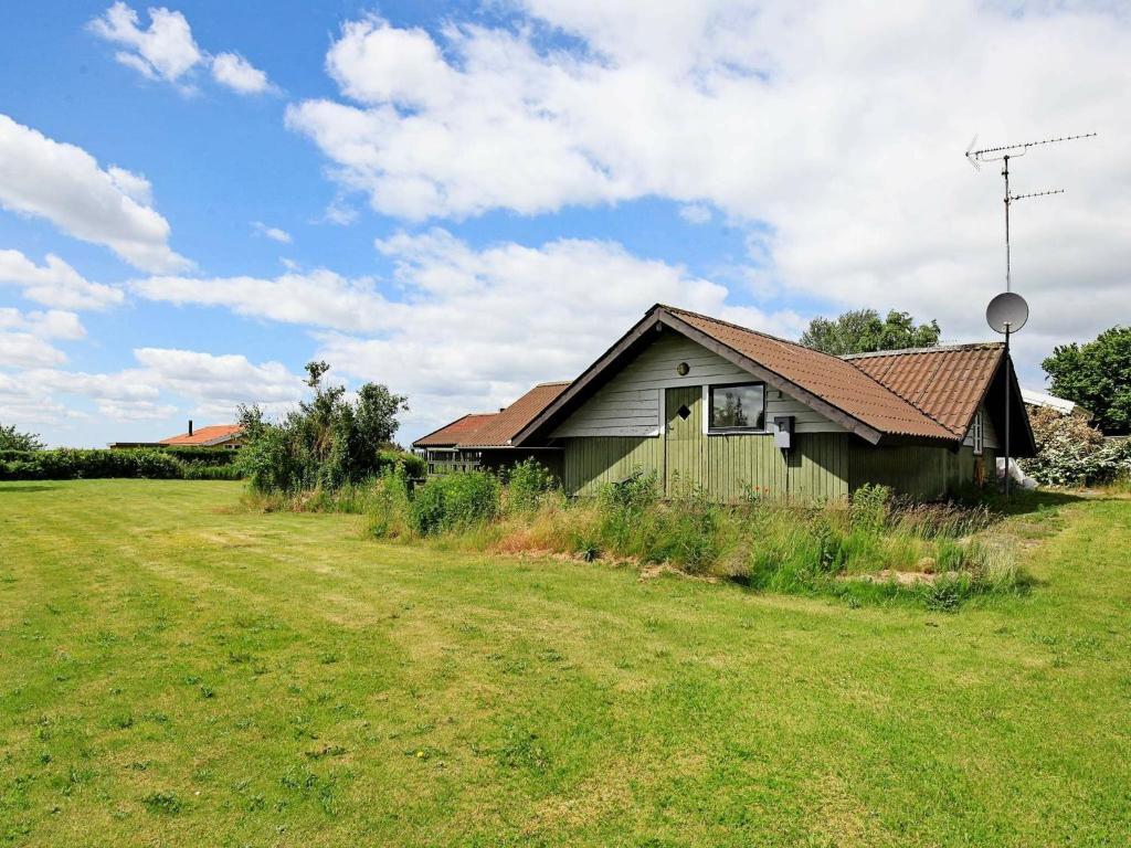 une maison verte dans un champ à côté d'un champ dans l'établissement 6 person holiday home in Skibby, à Skibby