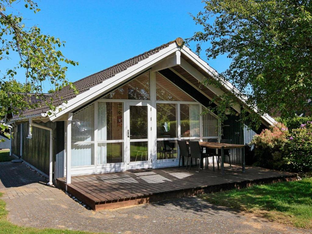 a small cottage with a deck and a table at 5 person holiday home in Esbjerg V in Esbjerg