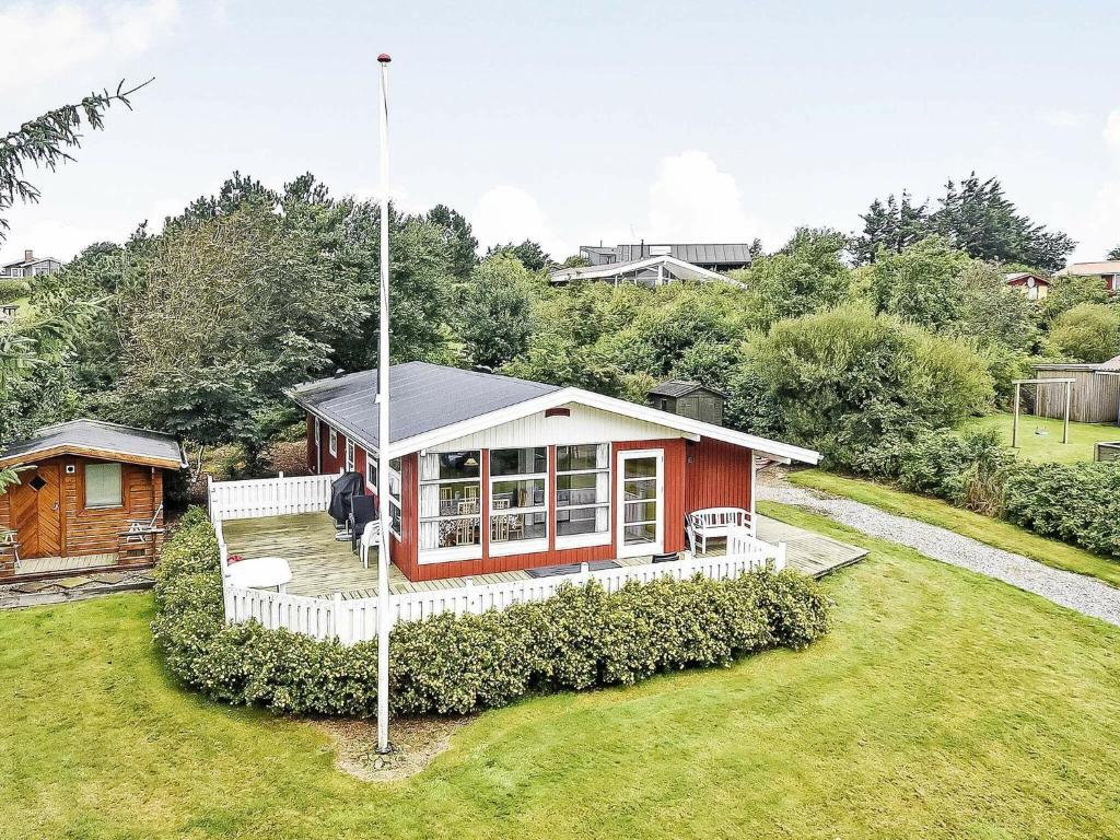 una pequeña casa roja y blanca en un patio en 8 person holiday home in Struer, en Struer