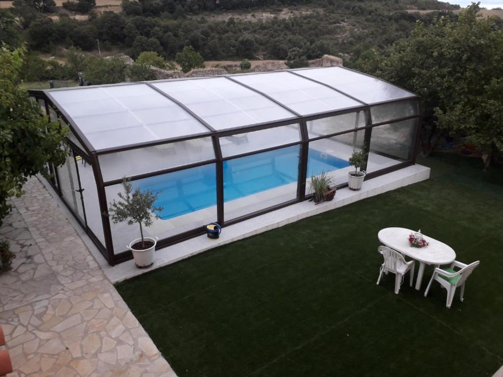 Una imagen de una casa de cristal con piscina. en Alojamiento Rural Abuela Andrea, en Molinilla