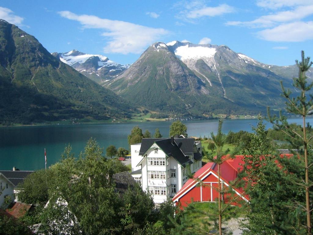 a town in front of a lake and mountains at Hjelle Hotel in Hjelle