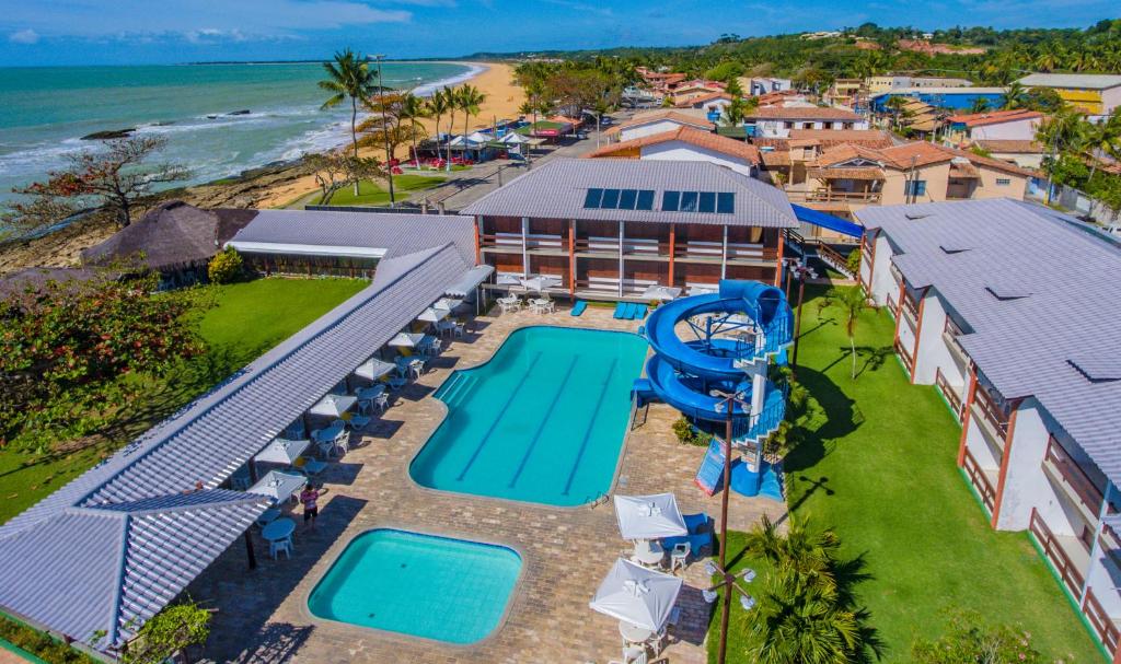 an aerial view of a resort with a pool and the ocean at Baia Cabralia Hotel in Santa Cruz Cabrália